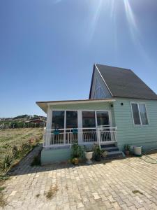 a green house with a porch and a person on it at DENİZE 5 DAKİKA VE DOĞA EVİ in Cesme