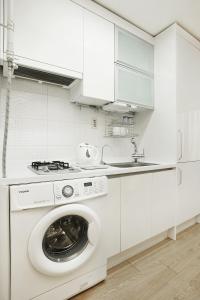 首尔现代住宅的带洗衣机和水槽的白色厨房