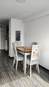 a dining room table with two chairs and a wooden table at Apartamento embajada americana in Bogotá