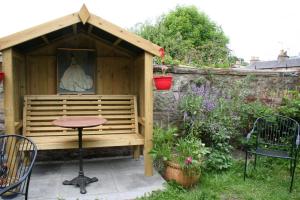um barracão de madeira com uma mesa e cadeiras num jardim em Argyle Backpackers em Edimburgo