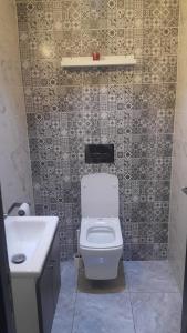 a bathroom with a white toilet and a sink at Résidence Repos in Casablanca