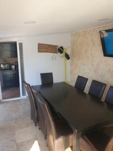 a dining room with a black table and chairs at Casa Happy in 2 Mai