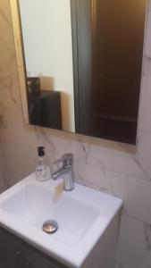 a bathroom sink with a mirror and aaucet at Résidence Repos in Casablanca