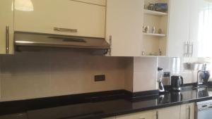 a kitchen with white cabinets and black counter tops at Résidence Repos in Casablanca