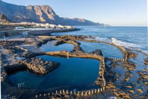 eine Luftblick auf einen Strand mit Felsen und das Meer in der Unterkunft Agaete White&Blue House in Agaete