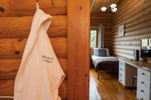 a bedroom with a bed and a towel hanging from a wall at Bullfinch - 2 Bed Lodge in Saxtead +4 photos