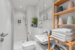 a bathroom with a shower toilet and a sink at PRIME: Design Apartment für 4 - Zentrale Lage in Munich