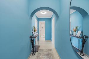 a hallway with blue walls and a mirror at PRIME: Design Apartment für 4 - Zentrale Lage in Munich