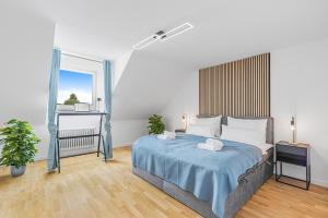 ein Schlafzimmer mit einem großen Bett mit einer blauen Decke in der Unterkunft PRIME: Design Apartment für 4 - Zentrale Lage in München