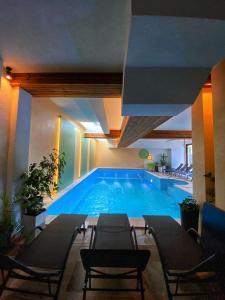 a large swimming pool with chairs in a building at Pensiunea Senin in Sovata