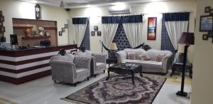 a large living room with couches and a rug at Apex Inn Guest House in Islamabad