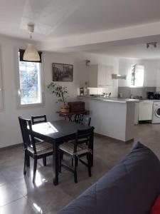 a living room with a table and chairs and a kitchen at Chez Pascal grand T2 de 55m2 indépendant dans villa in Sausset-les-Pins