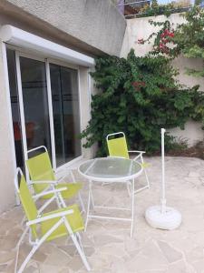 une table et des chaises assises sur une terrasse dans l'établissement Chez Pascal grand T2 de 55m2 indépendant dans villa, à Sausset-les-Pins
