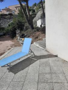 une chaise bleue assise sur un trottoir à côté d'un bâtiment dans l'établissement Chez Pascal grand T2 de 55m2 indépendant dans villa, à Sausset-les-Pins