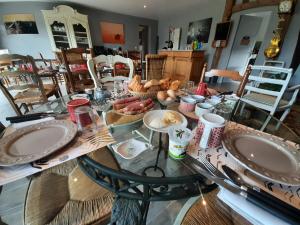 una mesa de cristal con comida encima. en Le lit de la Saâne, en Auzouville-sur-Saâne