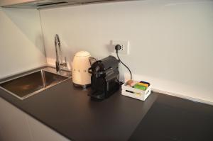un bancone della cucina con macchinetta del caffè e lavandino di Casa Narciso a Lazise
