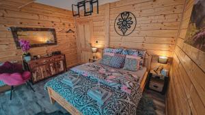 um quarto com uma cama num chalé de madeira em Chata na Skarpie - SPA i widok na Skrzyczne em Szczyrk