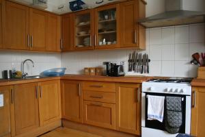 a kitchen with wooden cabinets and a white stove top oven at Argyle Backpackers in Edinburgh