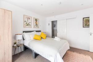 a bedroom with a large white bed with yellow pillows at Northumberland Boutique Guest House #1 in Coventry