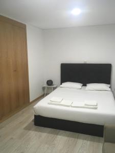 um quarto com uma cama grande e lençóis brancos em Casa do Castelo I em Brangança