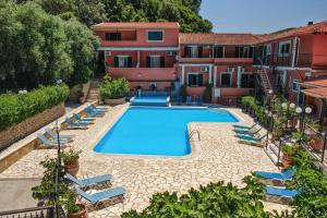 een zwembad met ligstoelen naast een gebouw bij Arianna apartment 14 in Paleokastritsa