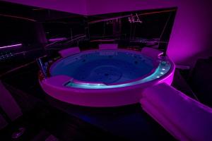 ein Badezimmer mit einem Whirlpool mit violetten Lichtern in der Unterkunft Le Loft Nancy in Nancy