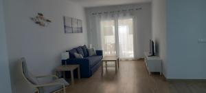 sala de estar con sofá azul y TV en SCALA Apartaments, en Salou