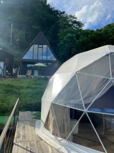 Mtirala Skhivi Cottage في باتومي: خيمة بيضاء أمام المنزل