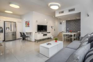 a large living room with a couch and a kitchen at Trust Inn garden in the city in Tel Aviv
