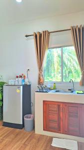 uma cozinha com um lavatório e uma janela em Amantra homestay & village em Surat Thani