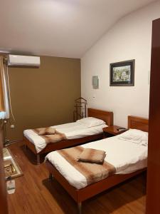 two beds in a room with wooden floors at Saint George in Strumica
