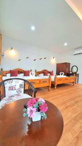 a living room with a table with flowers on it at Amantra homestay & village in Surat Thani