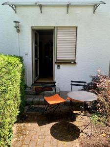 eine Terrasse mit 2 Stühlen und einem Tisch vor einem Haus in der Unterkunft Einladendes Appartement im Grünen für 2 Personen in Ostrach