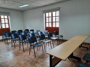 Zimmer mit Stühlen, Tischen und einem Holztisch in der Unterkunft Casa Wayra Cajamarca in Cajamarca