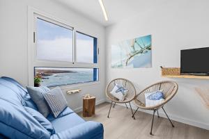 a living room with a blue couch and two chairs at Casa Azul by Escape Home in Punta de Mujeres