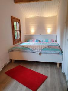 una camera con un letto e un tappeto rosso di Ferienhaus Seebrise - a90151 a Bad Bederkesa