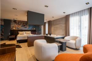 uma cozinha e sala de estar com uma cama e cadeiras em La Miel Suites em Şile