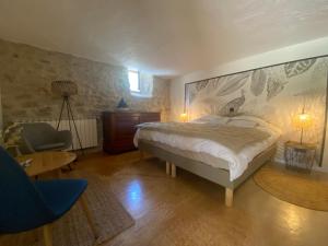 Schlafzimmer mit einem Bett, einem Schreibtisch und einem Stuhl in der Unterkunft mas du Belbuis in Rochegude