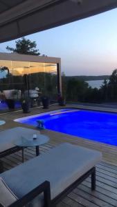 uma piscina em frente a uma casa com uma piscina azul em Leilighet i Sørlandshus i Son - Sjøutsikt - Nær Son Spa em Son