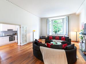 a living room with a black couch and red pillows at Pass The Keys Perfect Blend of Comfort Charm in London