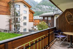 einen Balkon mit einem Tisch und Stühlen sowie Aussicht in der Unterkunft Chez Domi et Michou in Zermatt