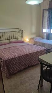 ガリポリにあるAttico Atlantideのベッドルーム1室(ベッド2台、テーブル付)