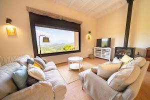 - un salon avec deux canapés et une grande fenêtre dans l'établissement HomeHolidaysRentals Paz - Costa Barcelona, à Vallgorguina