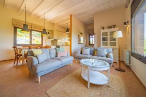 - un salon avec deux canapés et une table dans l'établissement HomeHolidaysRentals Paz - Costa Barcelona, à Vallgorguina