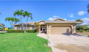a house with a garage and palm trees at Marco Island Retreat- close to beach ! in Marco Island