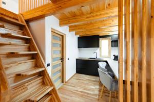 a kitchen with wooden walls and a staircase in a house at Terra Resort in Topliţa