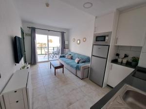 a kitchen and a living room with a couch and a table at Jesnery Home in Puerto del Carmen