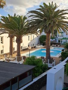 a resort with palm trees and a swimming pool at Jesnery Home in Puerto del Carmen