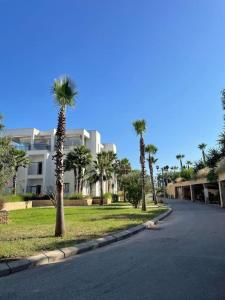 een straat met palmbomen voor een gebouw bij Apparemment luxueux Ritz Carlton in Sania Torres
