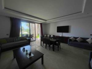 een woonkamer met een bank en een tafel bij Apparemment luxueux Ritz Carlton in Sania Torres